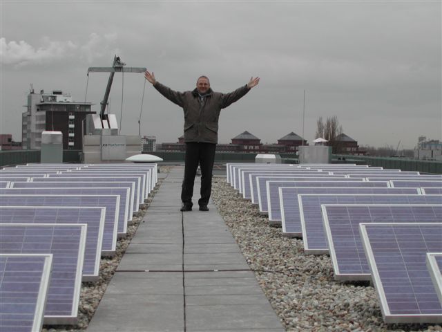 Blije wethouder voormalig stadsdeel Bos en Lommer na plaatsing zonnepanelen op stadsdeelkantoor.